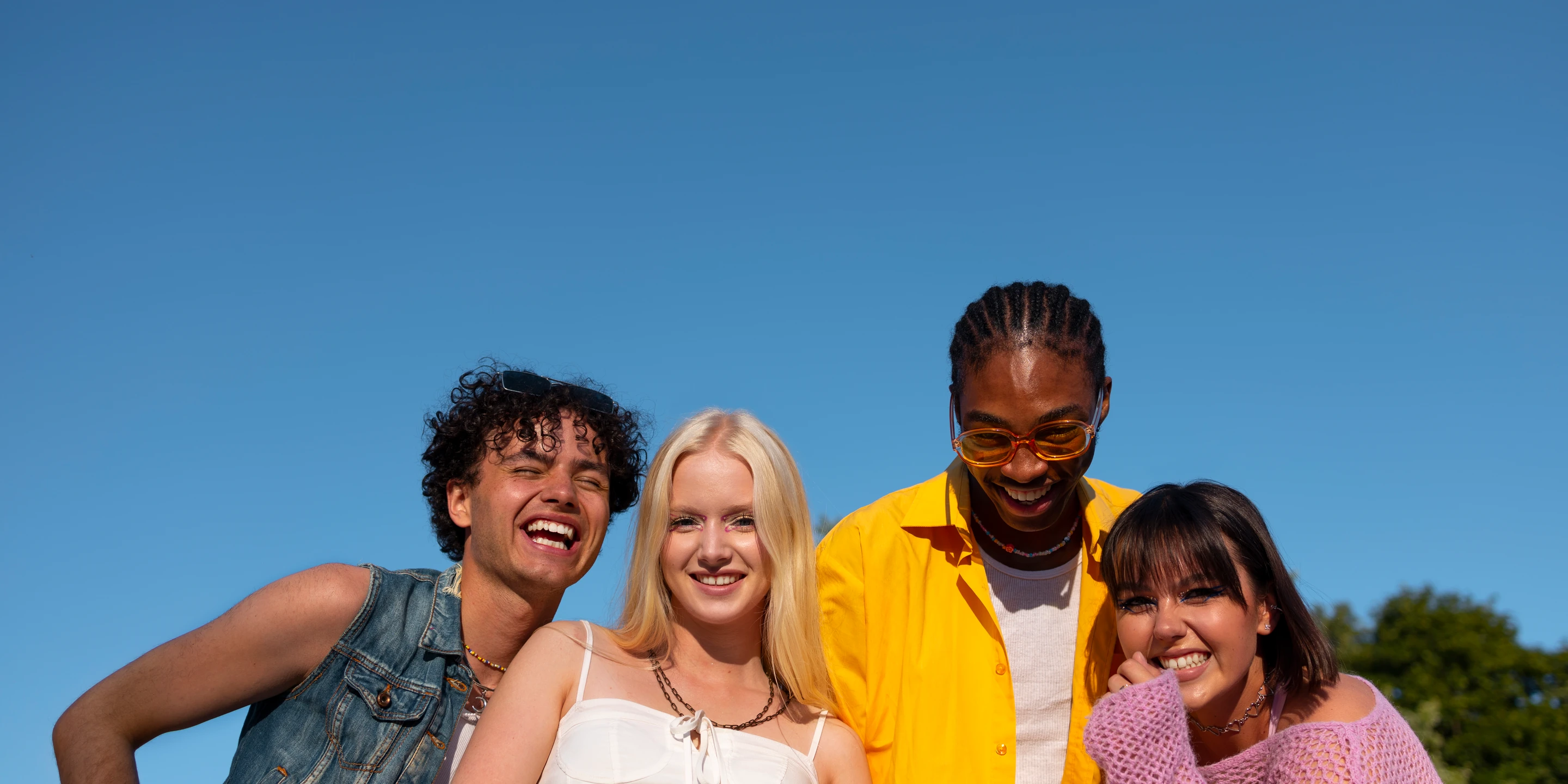 Four friends smiling together outdoors